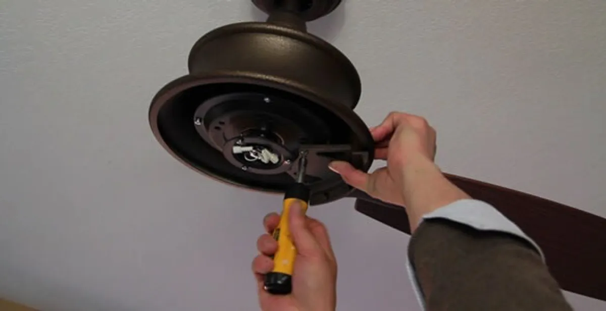 Electrician installing ceiling fan mounting bracket and fixture in San Diego, CA