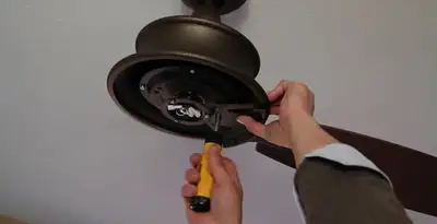 Electrician installing ceiling fan mounting bracket and fixture in San Diego, CA