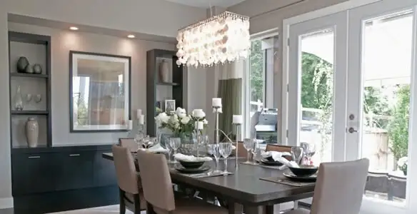 Elegant dining room chandelier installation above table in San Diego, CA
