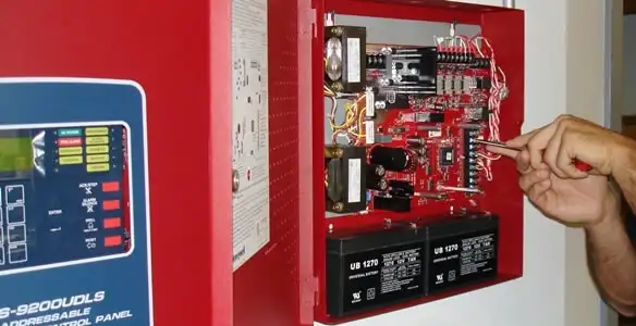 fire alarm installation service showing technician configuring fire alarm control panel in San Diego, CA
