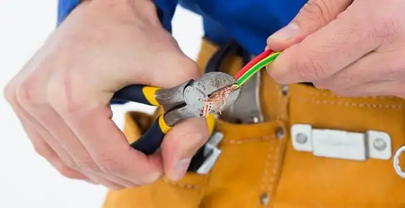 licensed electrician securing electrical wiring with professional tools during service work in San Diego, CA