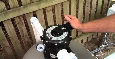 pool pumps service showing professional adjustment of pool pump control system in San Diego, CA